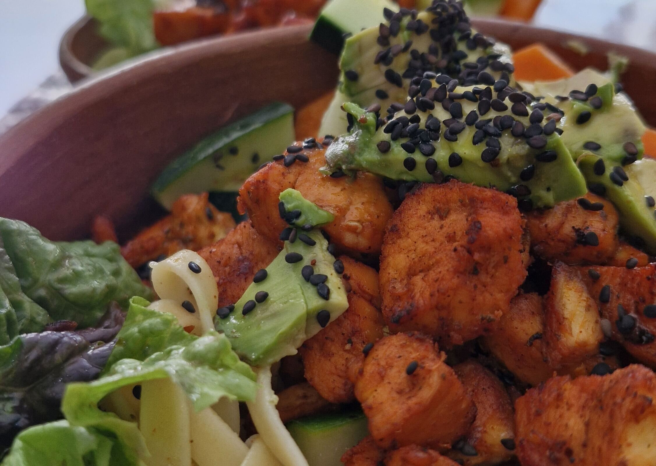 Tazón con pollo, aguacate, pepino, tallarines y ensalada