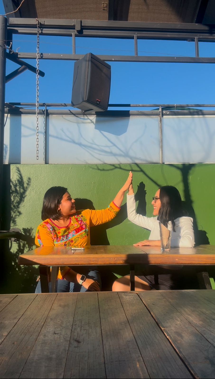 Yanely García chocando la palma con una paciente, sonriendo